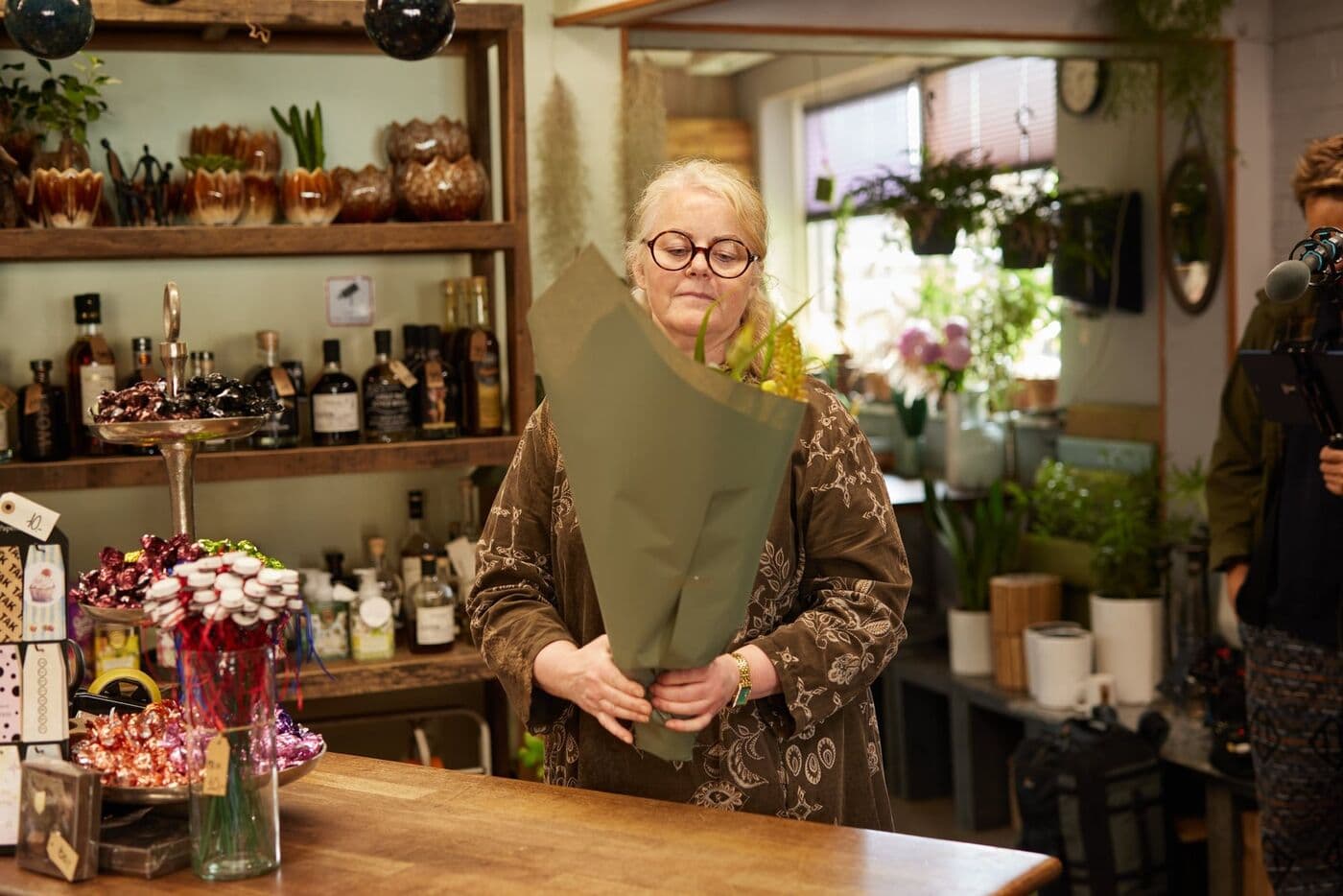 Blomsterhandleren bag disken i butikkens lys